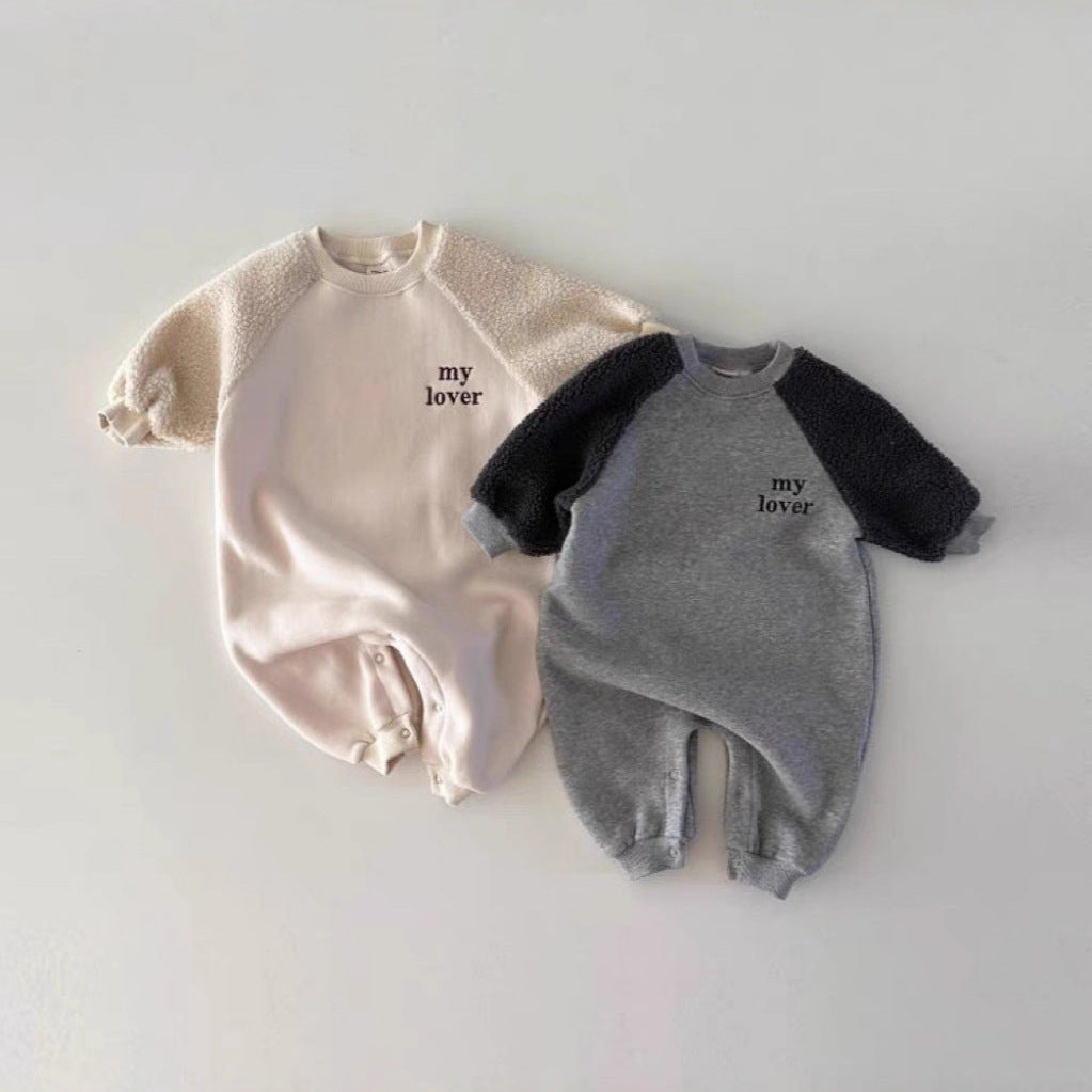 Two baby rompers, one beige and one gray with black sleeves, on a light gray background.