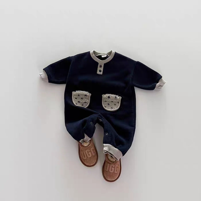 Navy blue baby romper with white accents on a white background