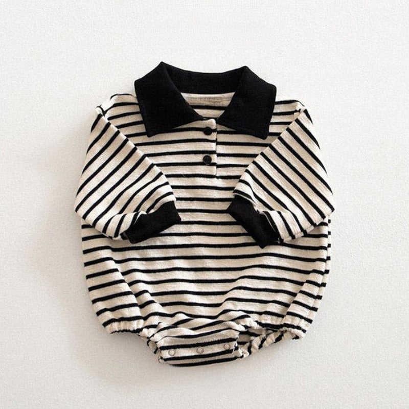 Black and white striped baby romper with a collar on a light background