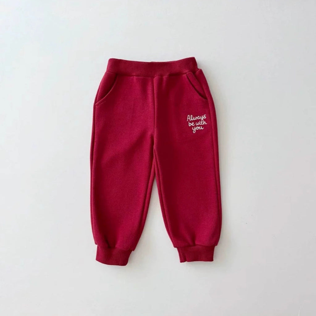 Red sweatpants with white text on a light gray background