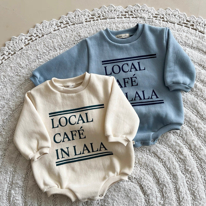 Two baby rompers, one white and one blue, with 'LOCAL CAFE IN LALA' text on a textured surface.