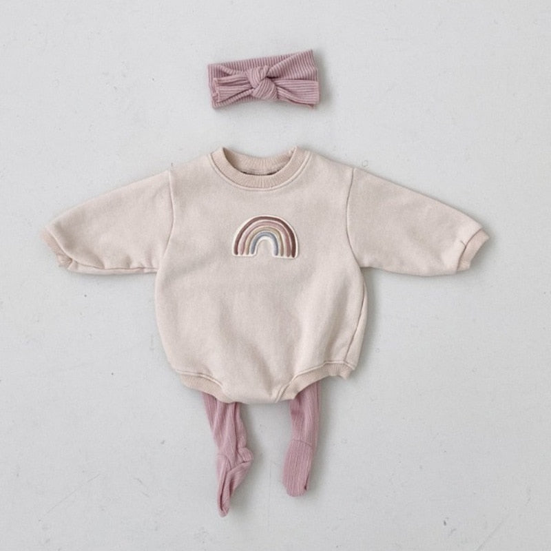 A gray Neutral Rainbow Bodysuit for babies with long sleeves, an O-neck collar, and footie coverage. The bodysuit features a rainbow print on the front.