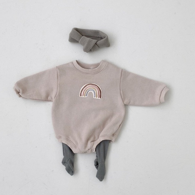 A gray Neutral Rainbow Bodysuit for babies with long sleeves, an O-neck collar, and footie coverage. The bodysuit features a rainbow print on the front.